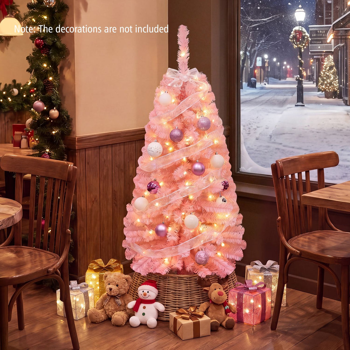 Pink Christmas tree wrapped in ribbon and glowing lights, surrounded by gifts and toys in a cozy dining room.