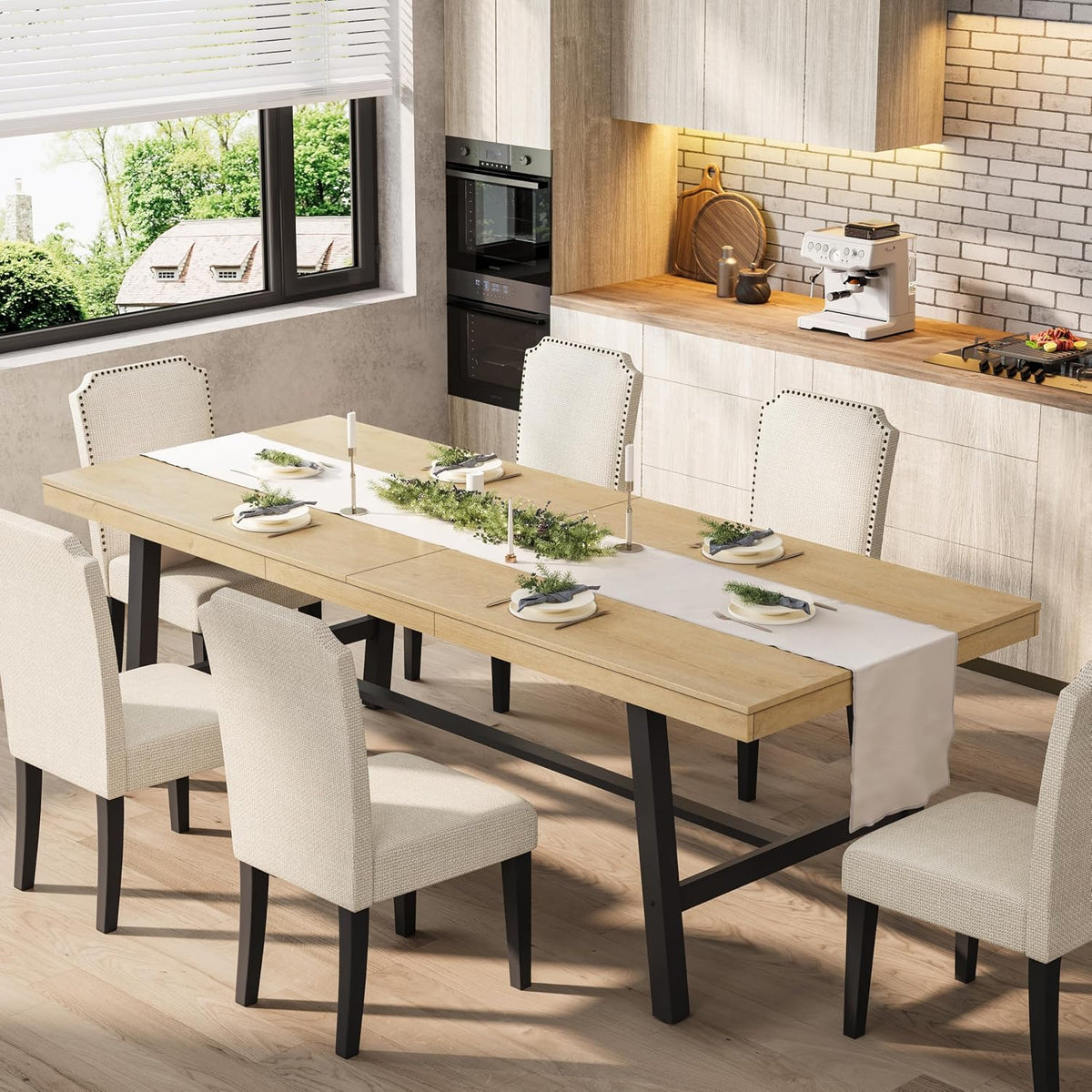 Light oak extendable table with black metal base set with plates and candles in a bright kitchen