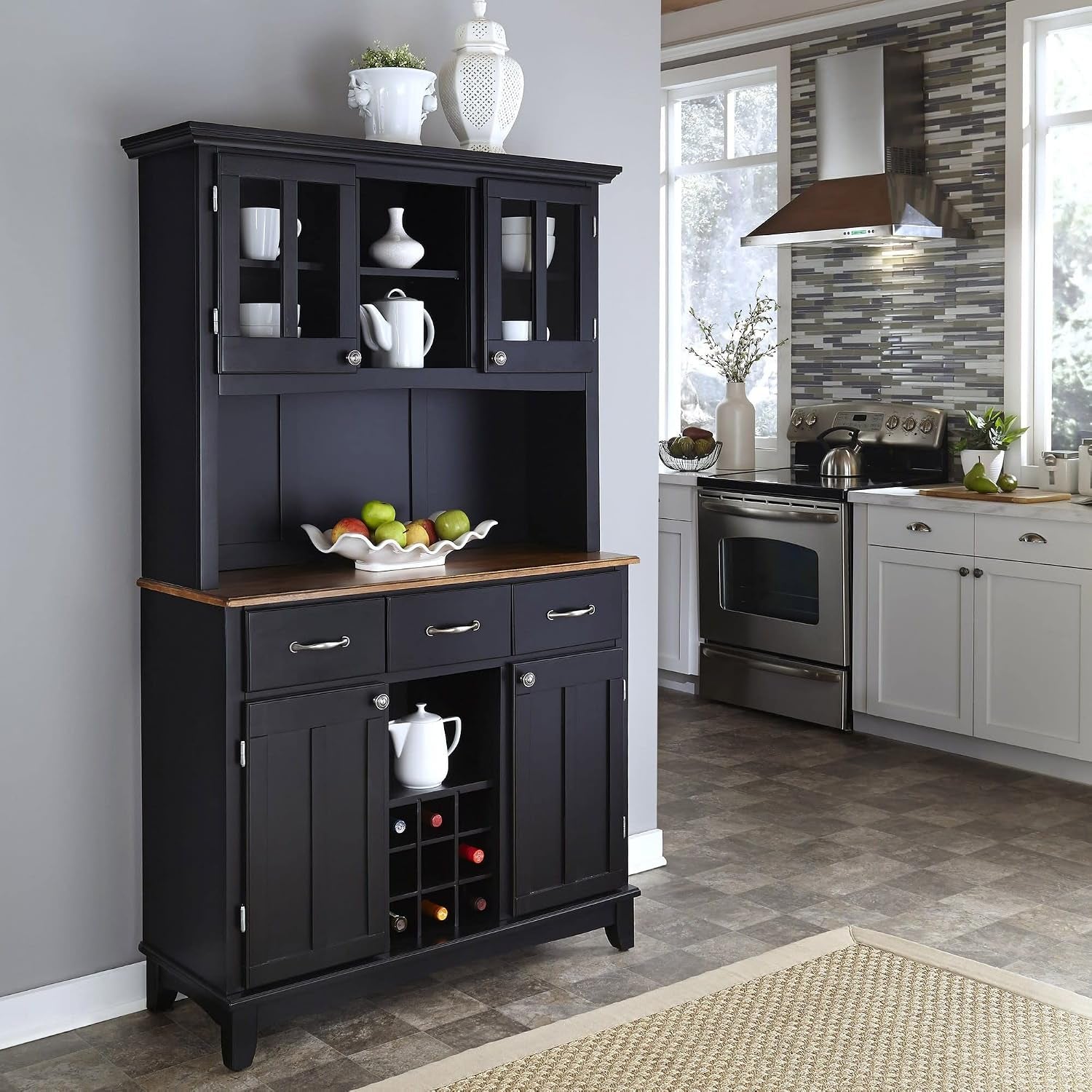 Full kitchen scene with a black hutch and buffet against a gray wall next to stainless steel appliances.