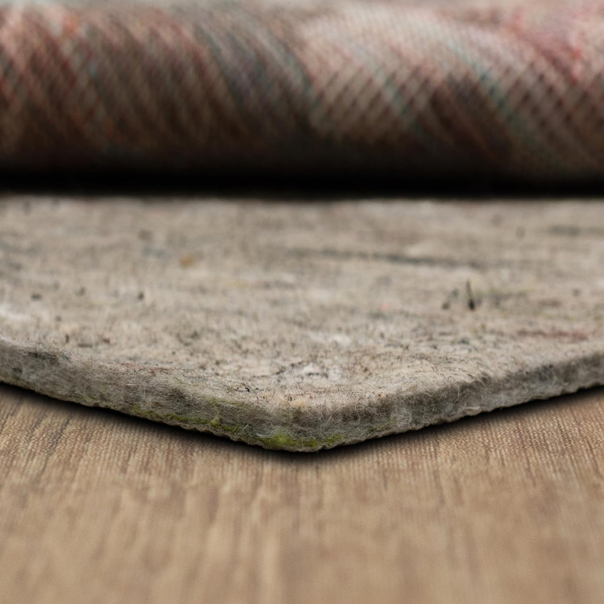 Angled detail of the pad corner with faint green recycled fiber flecks visible along the underside edge.