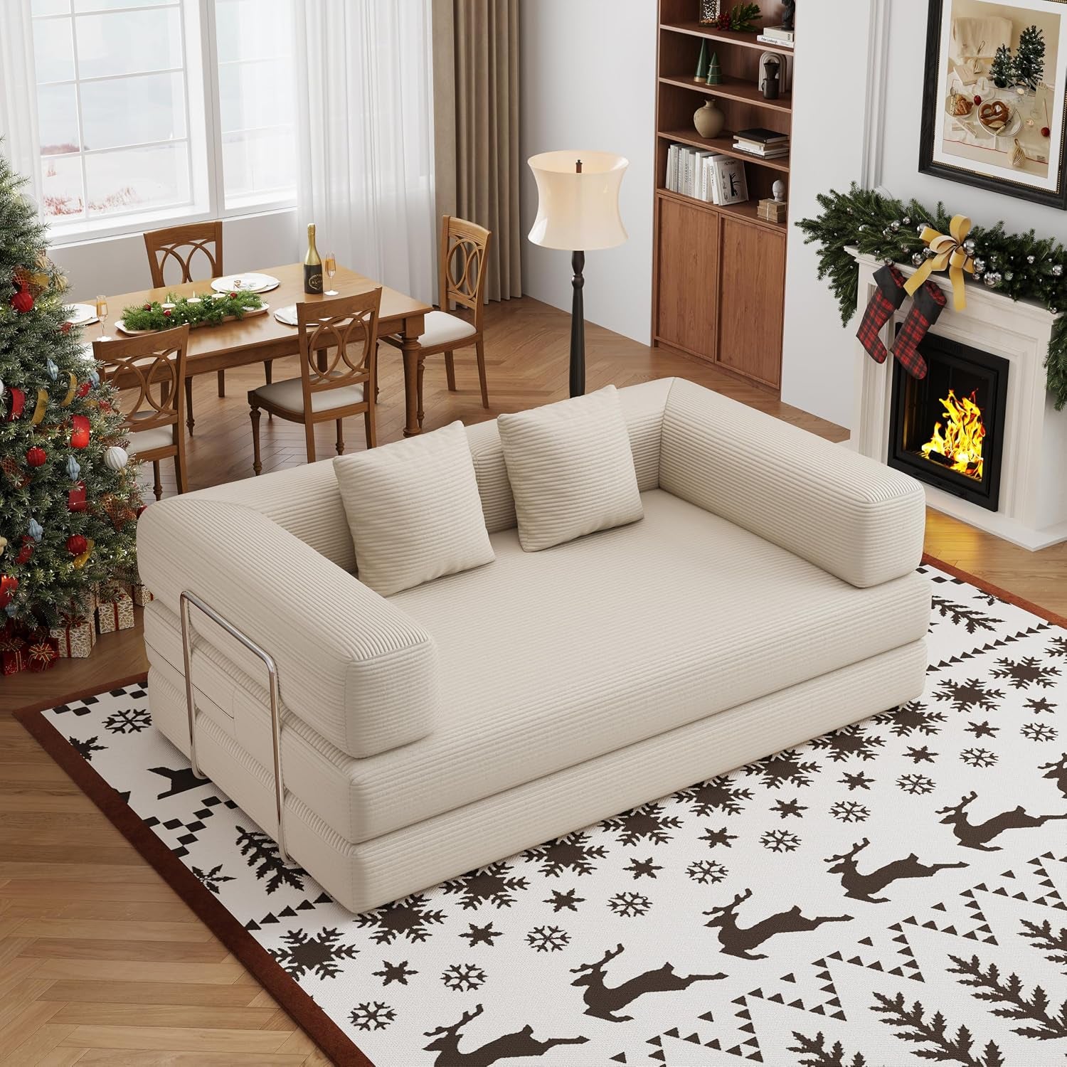 Angled view of a beige corduroy two-seat convertible floor sofa near a fireplace and decorated tree