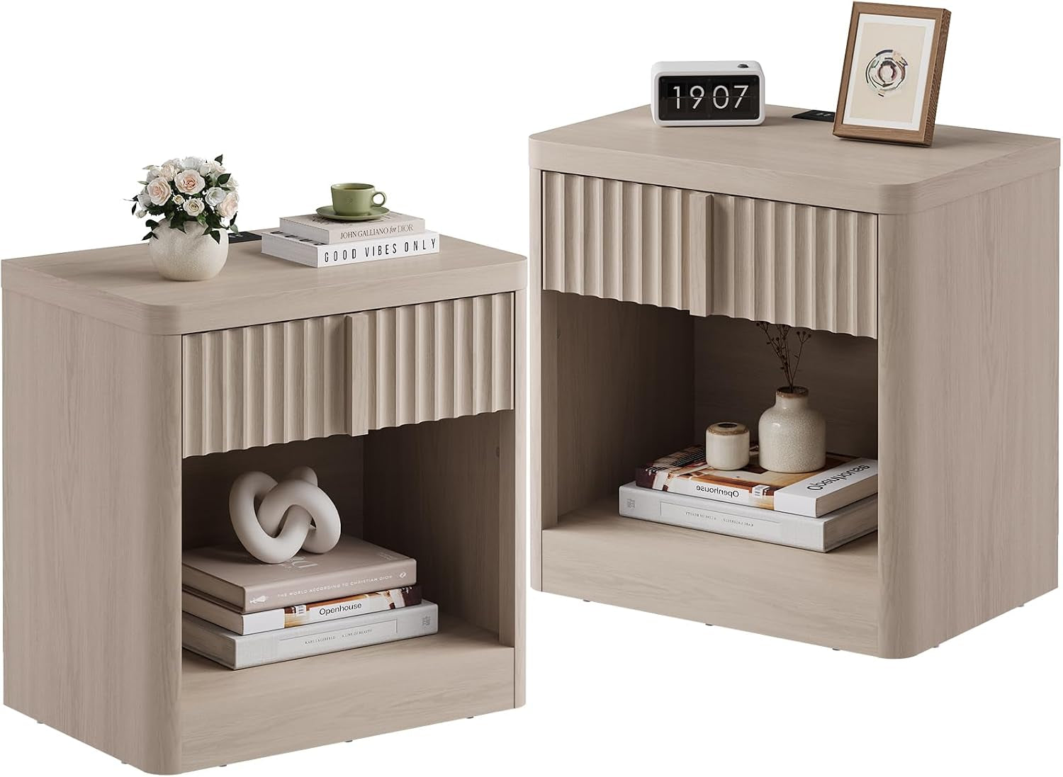 Pair of pale wood nightstands showing open-shelf configuration with books, vases, and framed art on top.