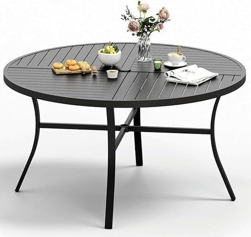 Black round metal patio table with slatted top on a white studio background with snacks and decor