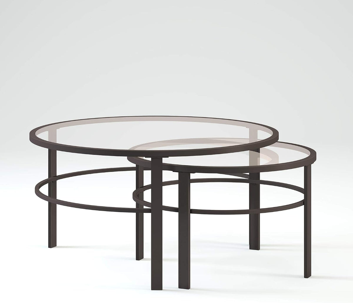 Pair of round tempered glass nesting tables with blackened bronze frames, angled side view on white