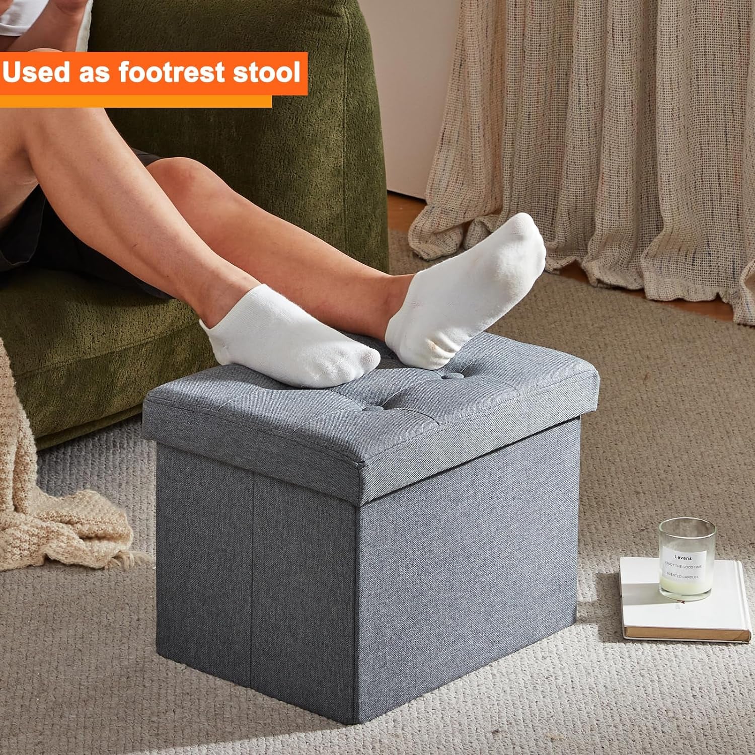 Grey tufted ottoman used as a footrest with feet resting on the padded lid