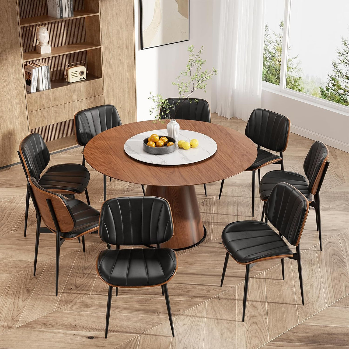 Top-down view of a round wood table with eight black faux-leather chairs showing walnut backs.