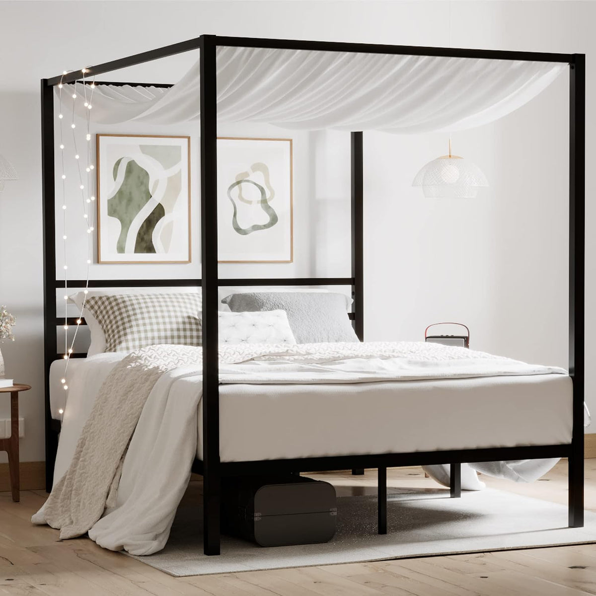 Black canopy bed head and frame with draped fabric and string lights in a styled bedroom