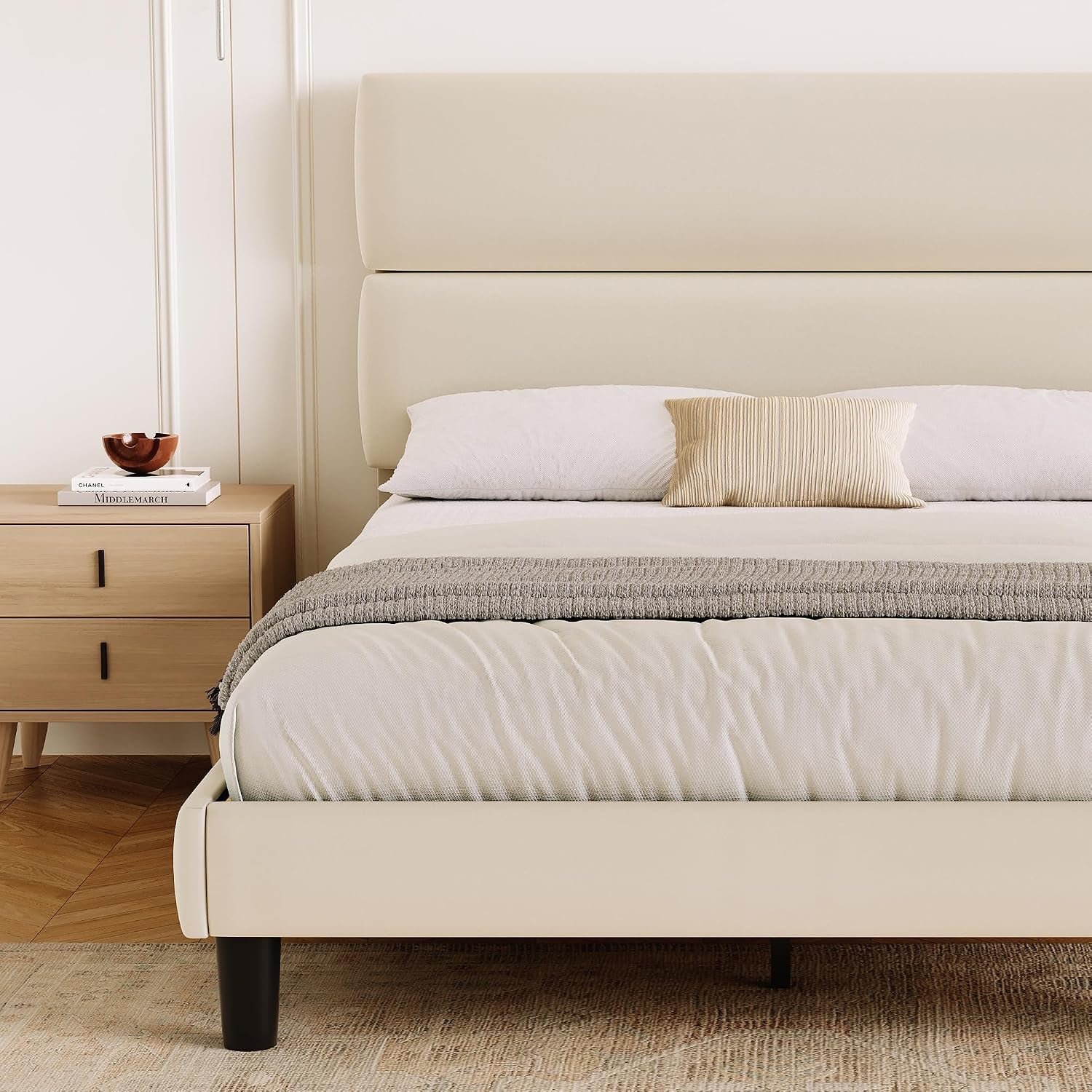 Close front view of the cream bed, highlighting the two-panel headboard and upholstered footboard.