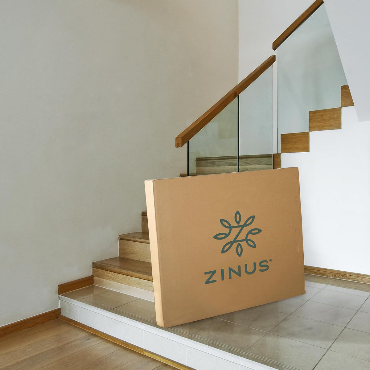 Cardboard mattress box with a floral logo leaning on indoor stairs