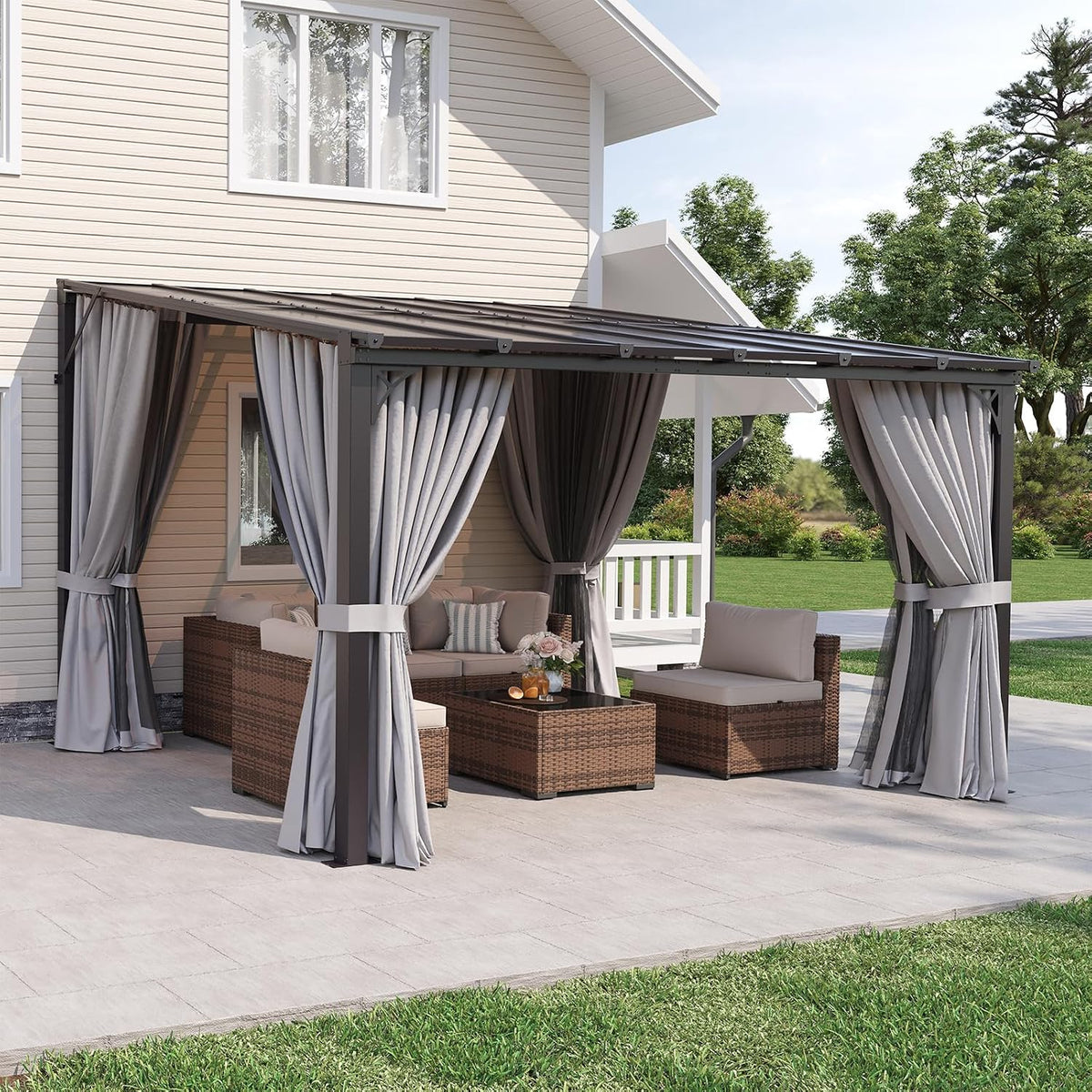 Side view of a wall-mounted pergola with draped curtains, a coffee table and cushioned patio seating.