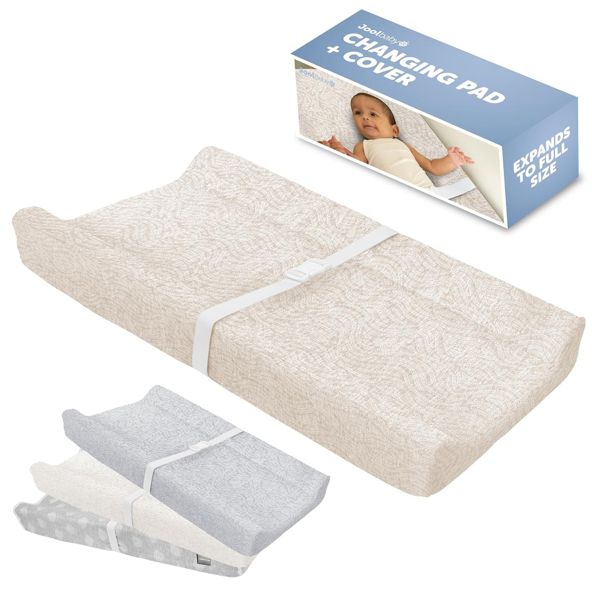 Beige contoured changing pad shown at angle with white safety strap and product box in background
