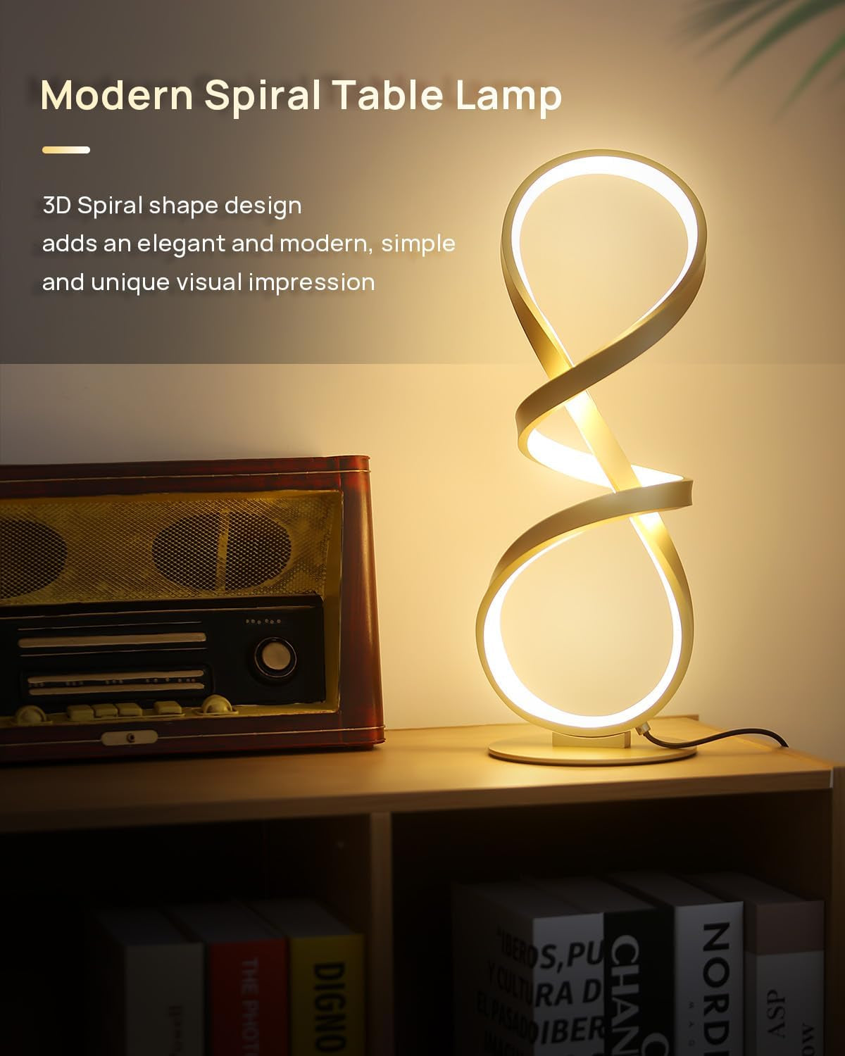 Gold spiral lamp lit on a wooden surface beside a vintage radio, angled close-up showing the infinity-loop form.