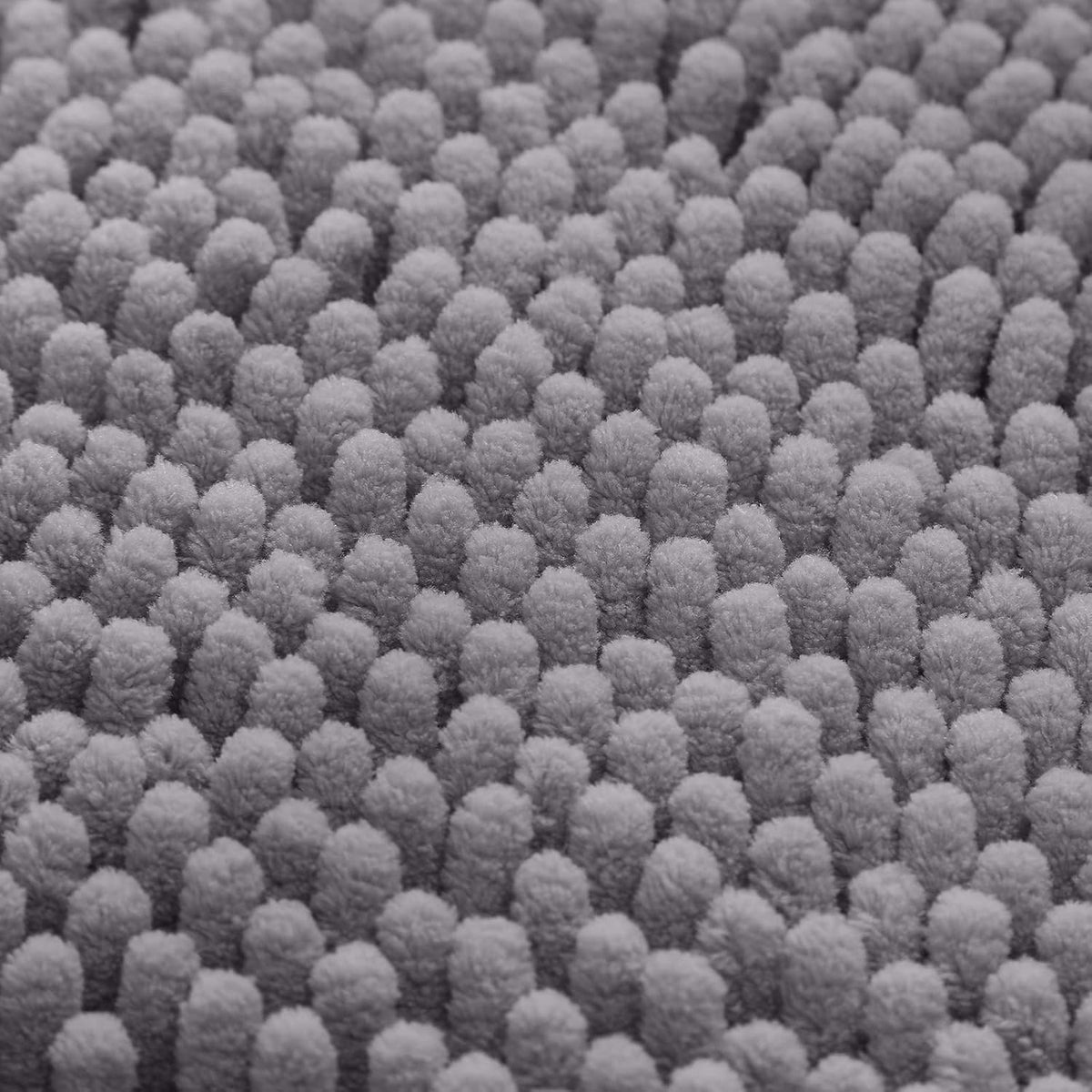 Close-up macro view of dense grey chenille nodules forming the rug's plush surface.