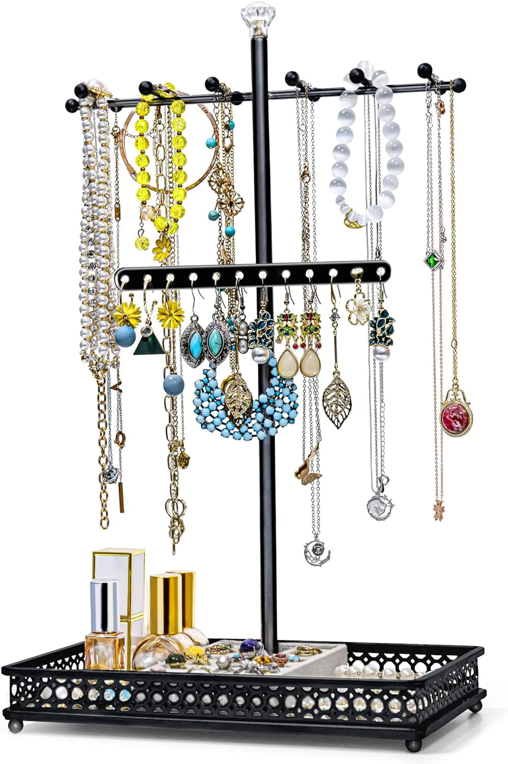 Black metal three-tier jewelry tree on a matching lattice tray styled with perfume bottles and assorted jewelry