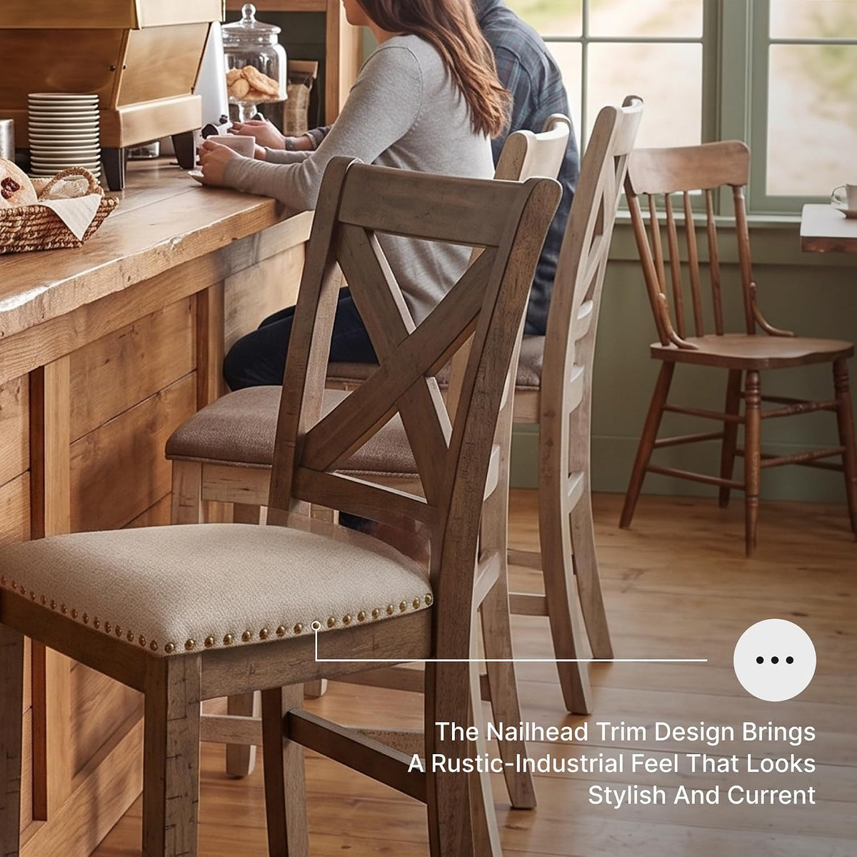 Three counter stools in a row showing X-back wooden frames and beige seats with nailhead trim at a cafe counter.