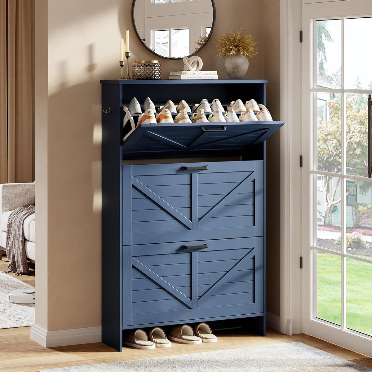 Blue shoe cabinet with top flip compartment open showing multiple pairs of shoes and a bottom shelf with slippers.
