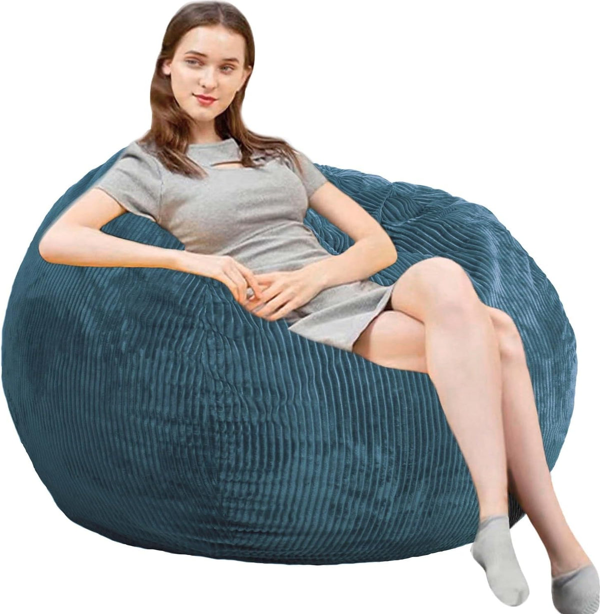 Side view of a woman lounging on a deep teal ribbed round bean bag chair.