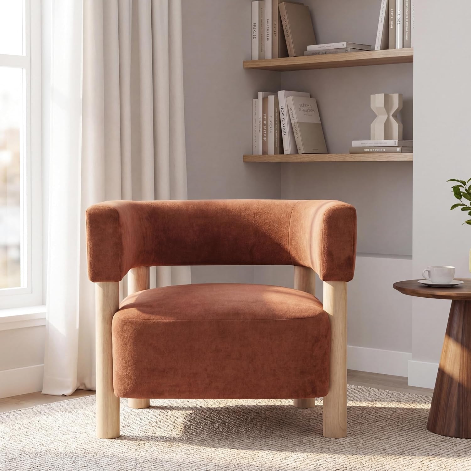 Armchair in a sunlit room with wood legs beside a small round table and wall shelves, rust upholstery