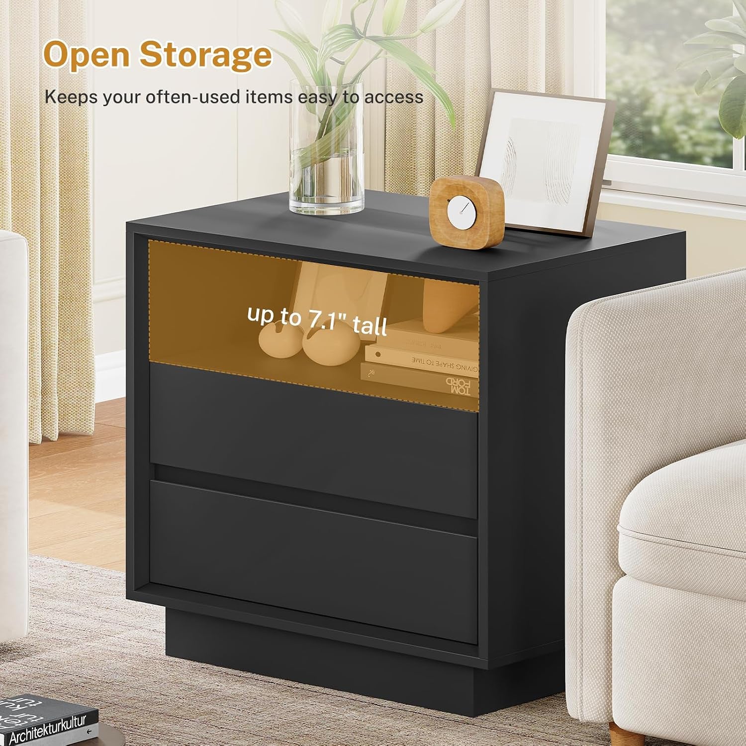 Front view of the black nightstand highlighting the open storage shelf above two drawers next to a sofa.