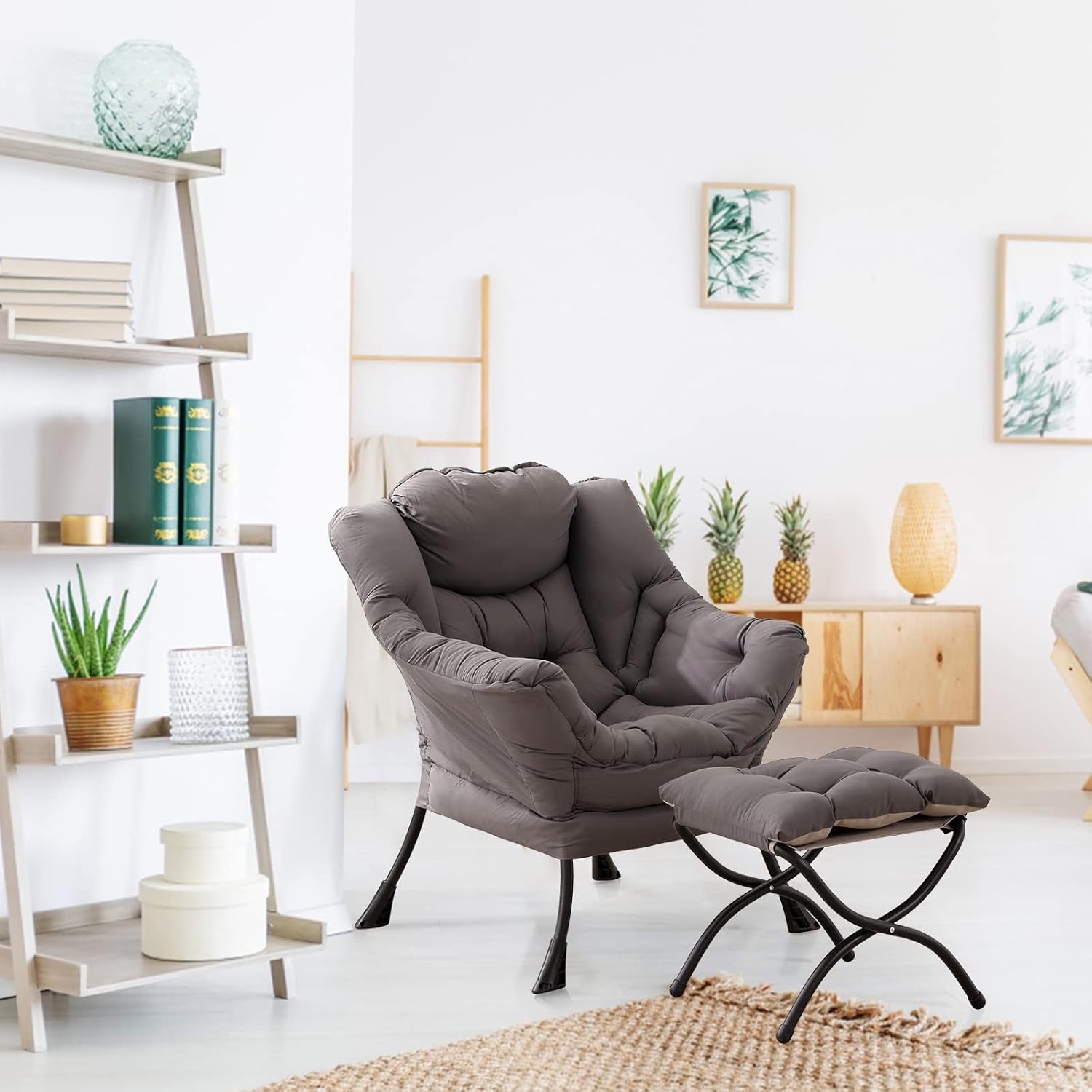 Plush gray padded lounge chair with matching foldable ottoman in a bright living room.