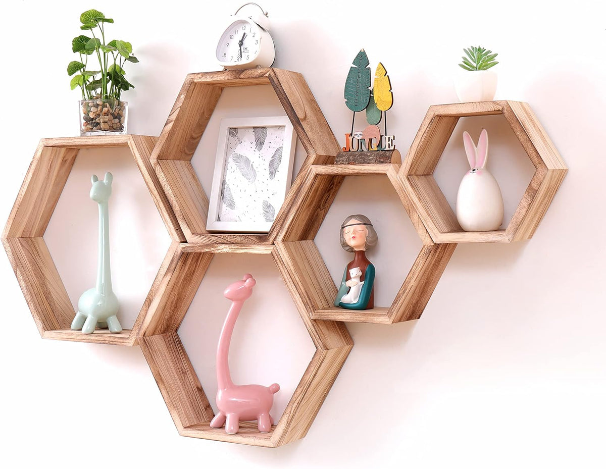 Light brown driftwood hexagonal shelves arranged on a white wall with small decor items