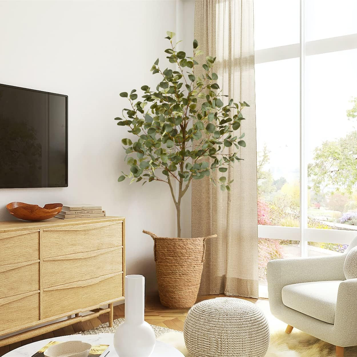 6 ft artificial eucalyptus tree in a woven basket beside a wooden dresser in a bright, styled living room scene