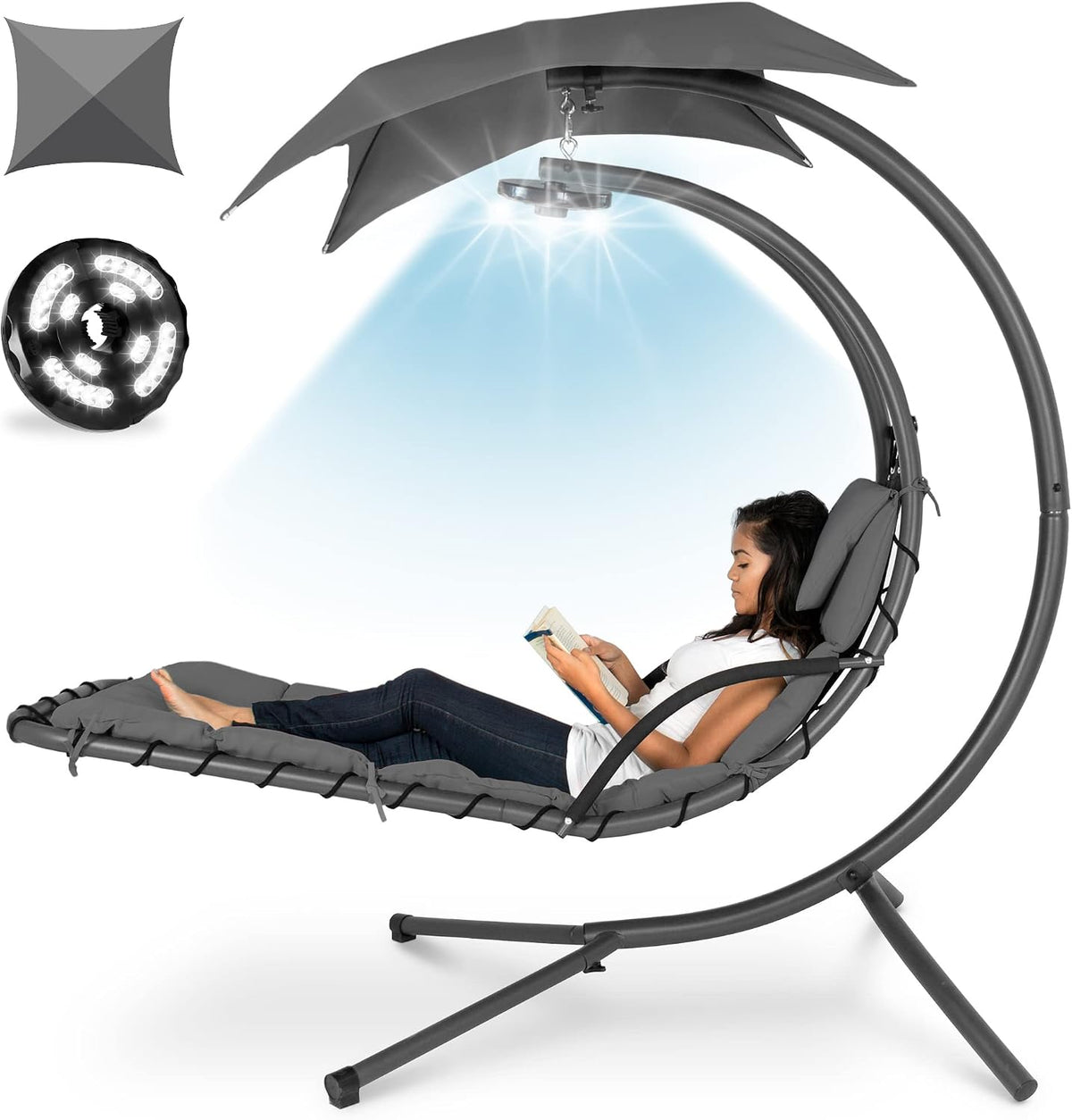 Same hanging chaise in dark gray cushions with overhead light shining down as woman reads