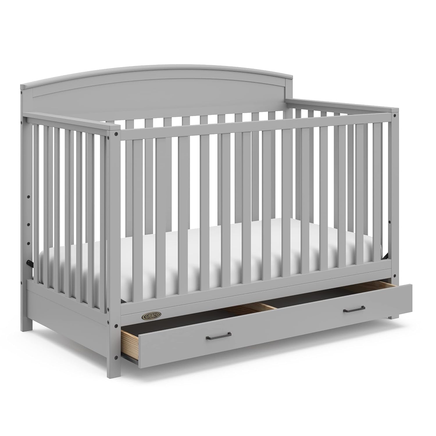 Front three-quarter view of a light gray convertible crib with lowered mattress and open storage drawer.