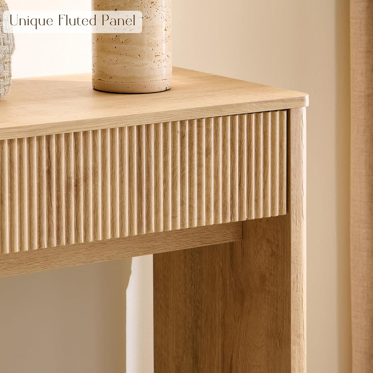 Close-up of the fluted drawer front and rounded top corner with a portion of the leg beneath.