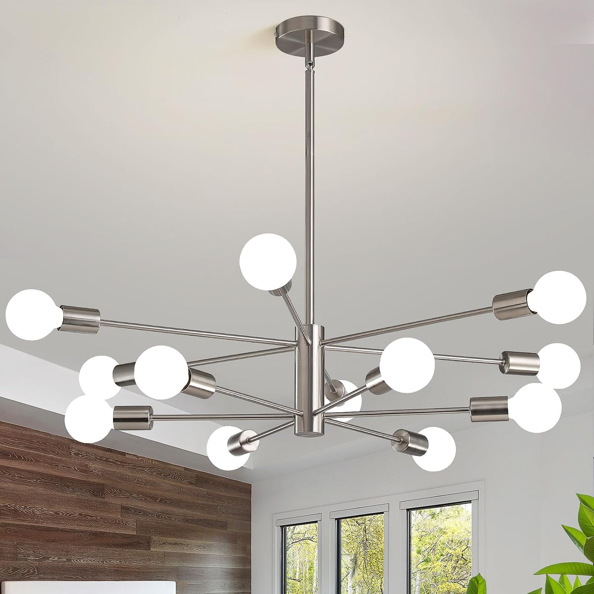 Ceiling-mounted 12-arm chandelier with round white bulbs in a silver finish over a dining area.