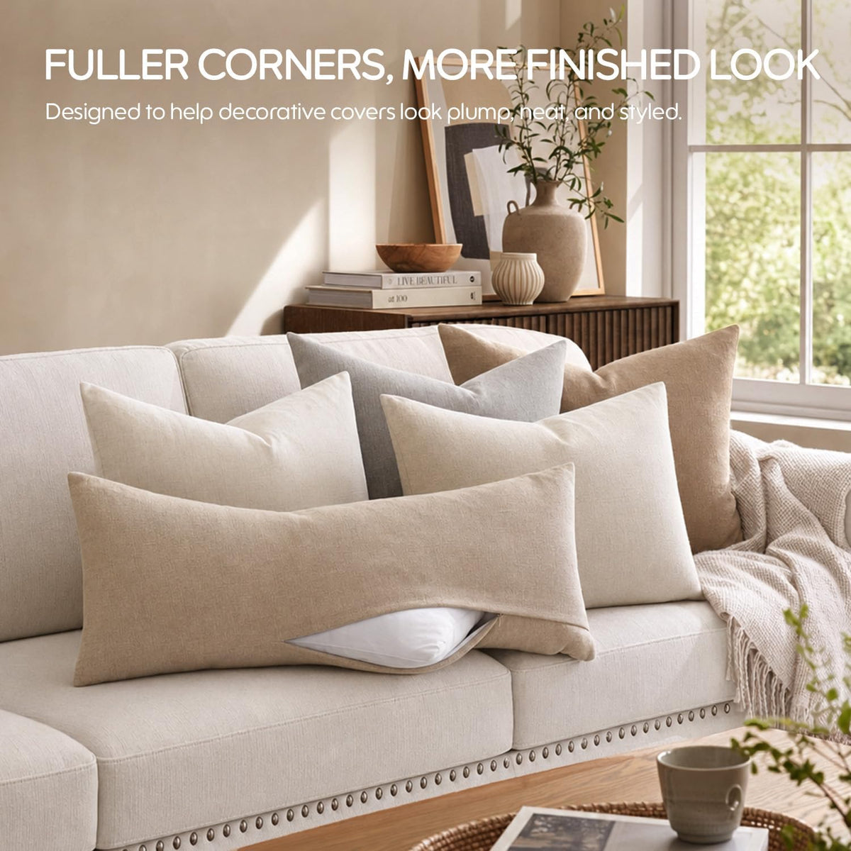 Sofa vignette with multiple covered throw pillows and one long lumbar cover partially open showing white insert.