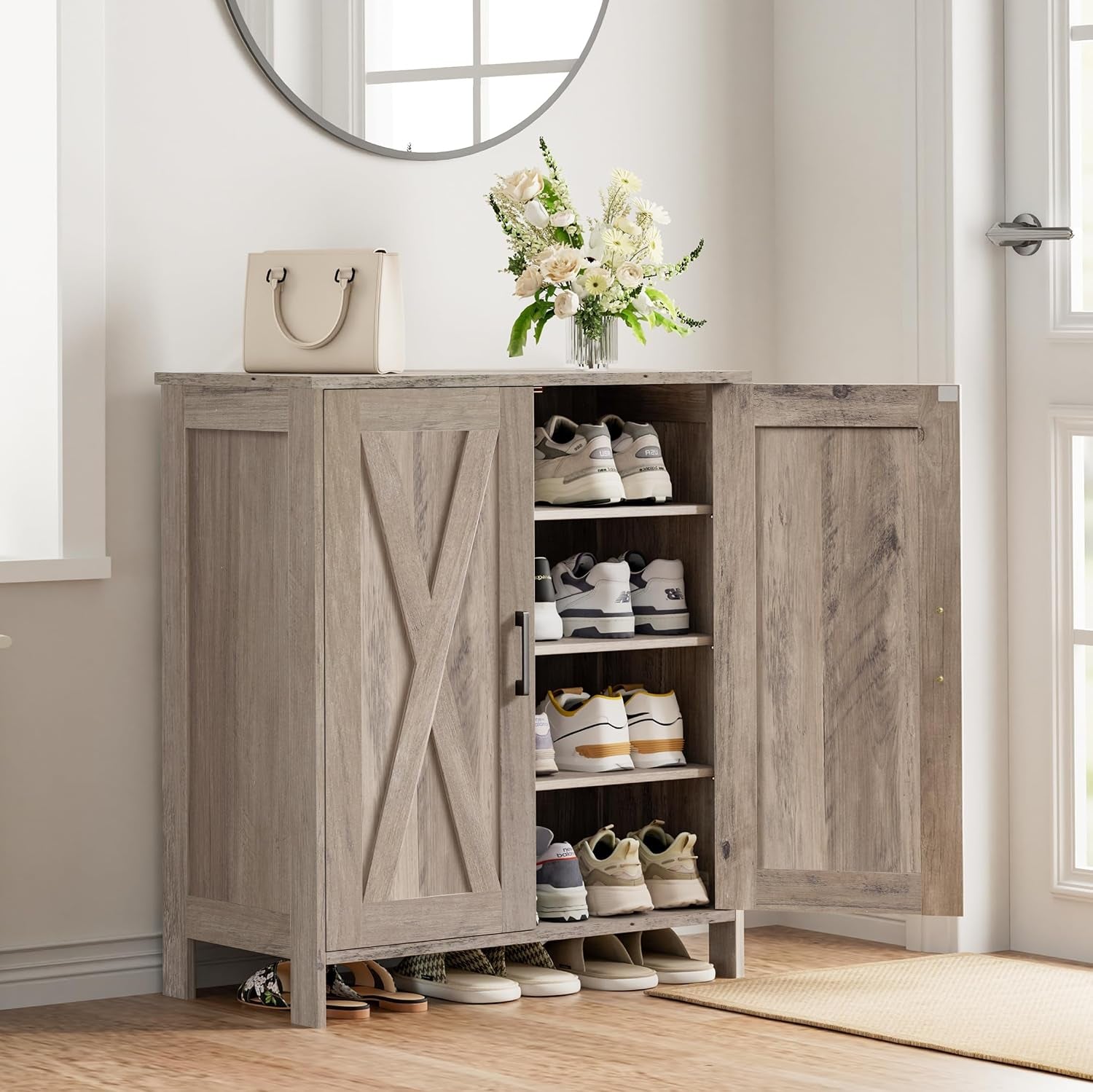 Light gray wood-look shoe cabinet in an entryway with open doors and shoes stored on four shelves.