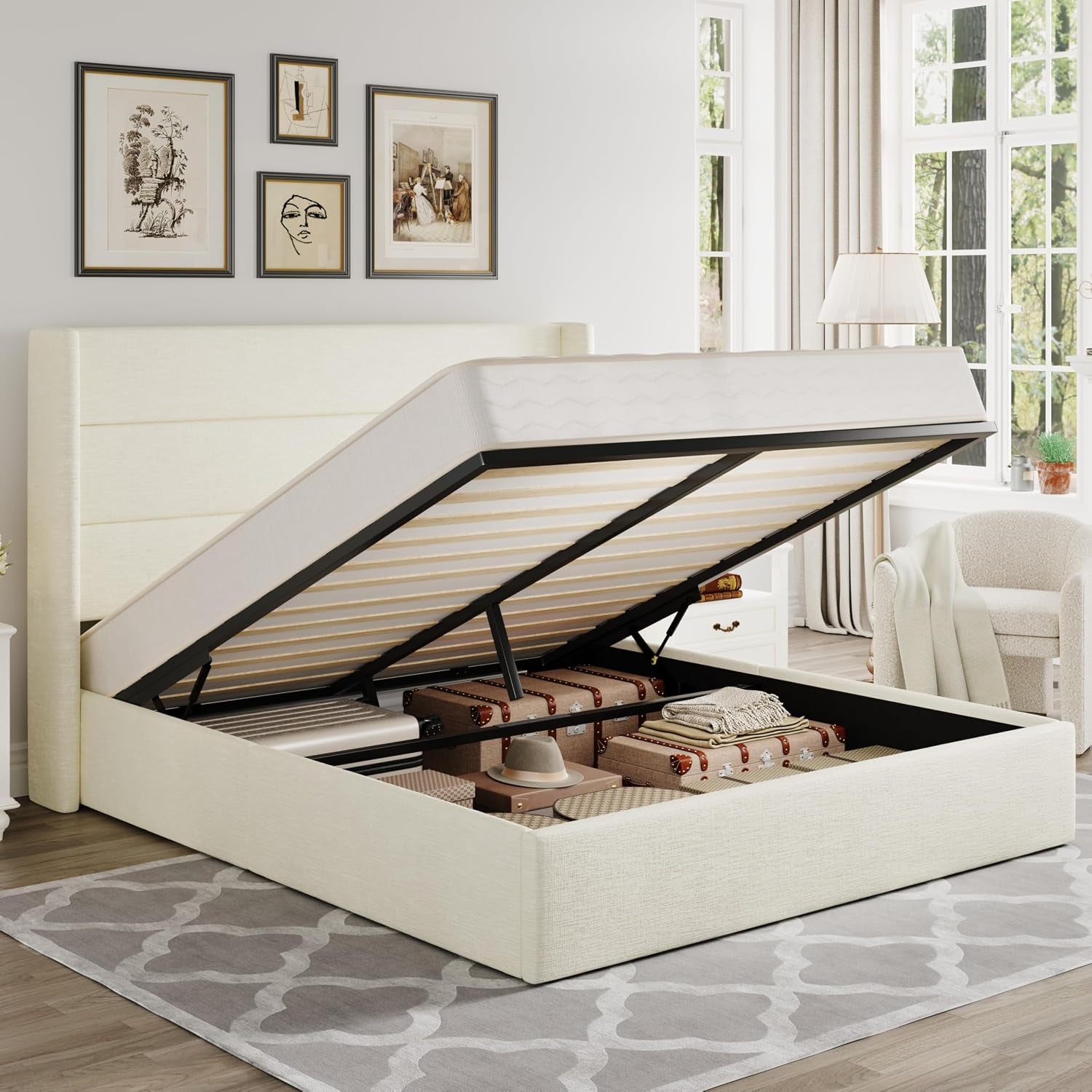 Cream upholstered bed with wingback headboard lifted to reveal organized under-bed storage with boxes and a hat