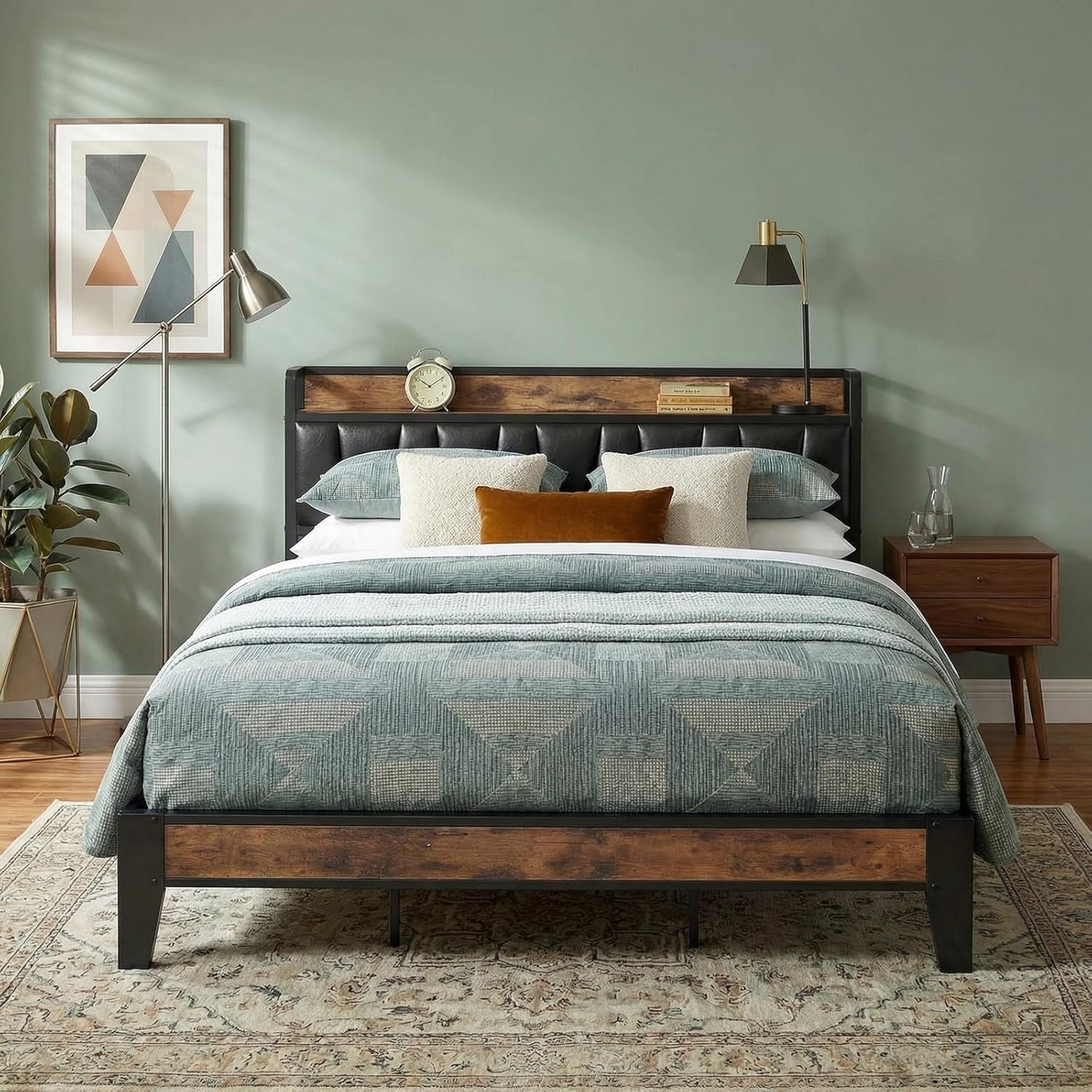 Front-facing shot of a bed with tufted black headboard, wood trim and green bedding in a styled bedroom.