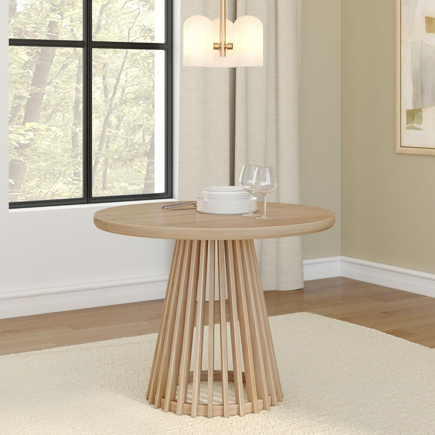 Three-quarter view of the round slatted pedestal table in a light dining setting