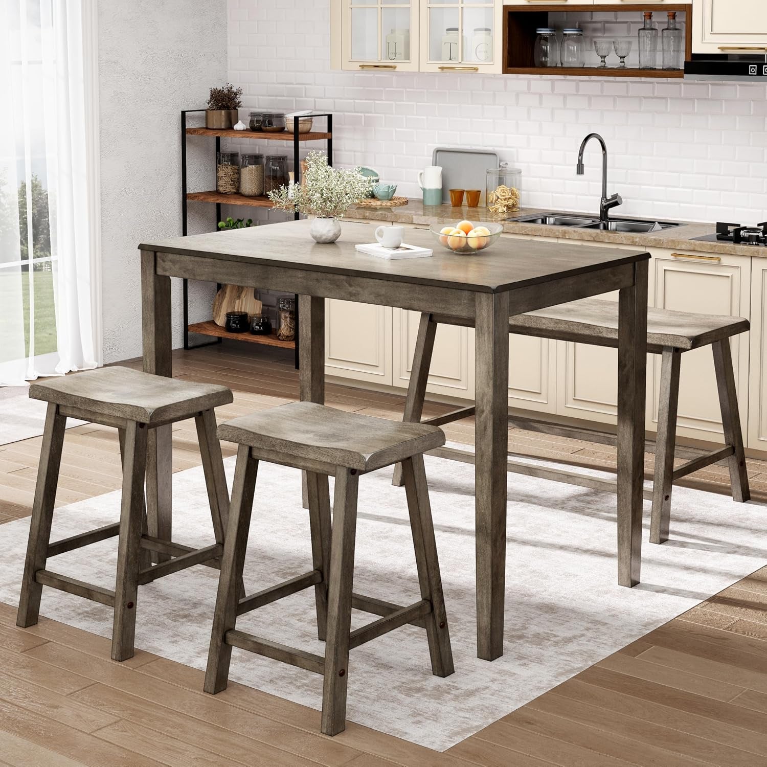 Table with two stools and a bench placed in a kitchen setting atop a rug, styled with a vase and bowl.