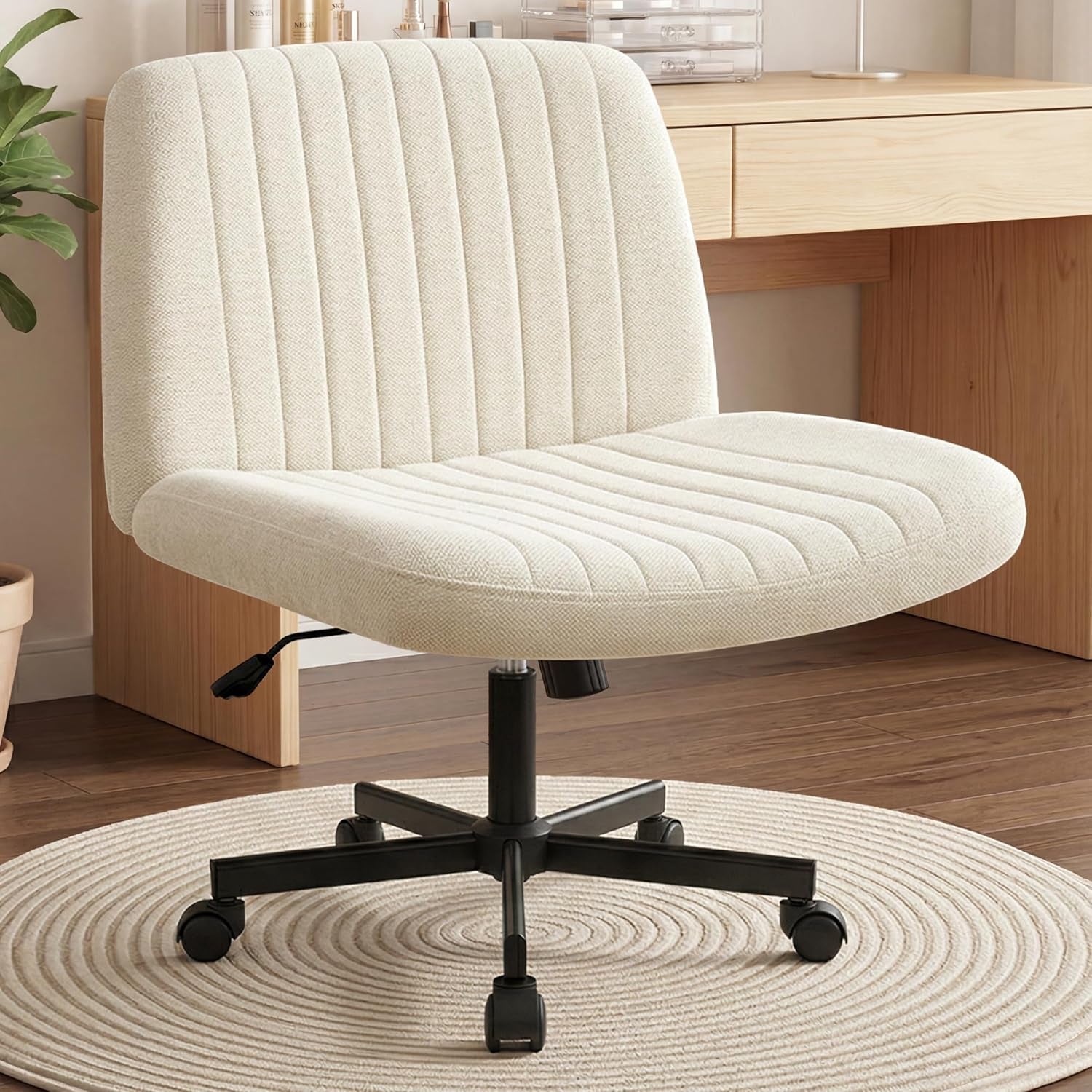 Cream beige armless swivel desk chair angled front view showing ribbed upholstered seat and black metal base with casters
