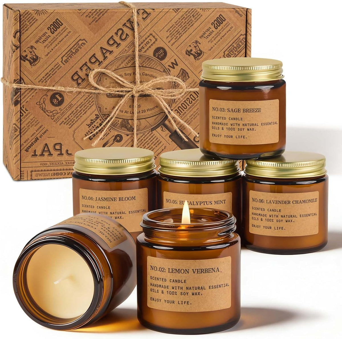 Kraft gift box tied with twine behind grouped amber jars, one candle lit and another jar shown lying on its side