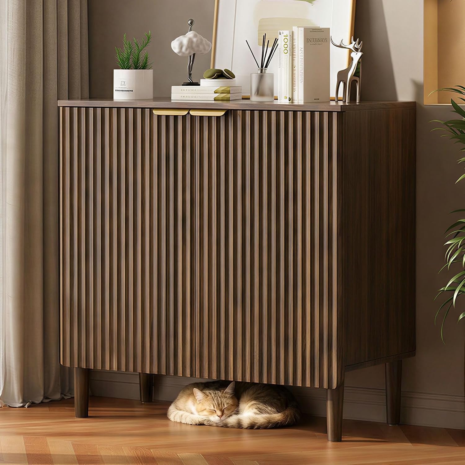 Front view of walnut groove-front sideboard on wood floor with cat sleeping beneath and decorative items on top