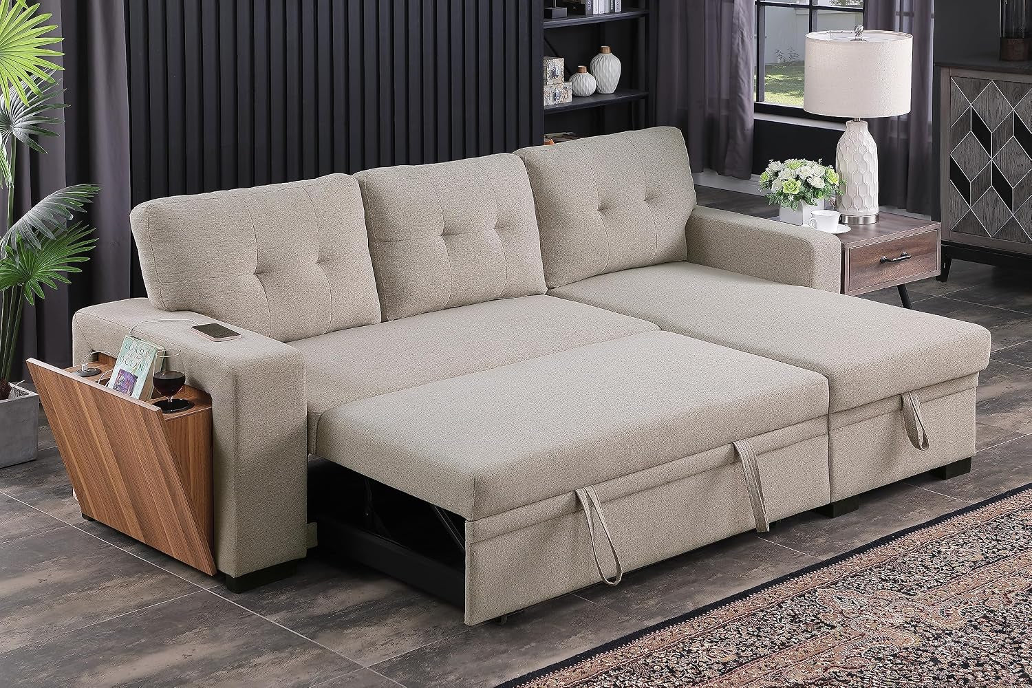 Beige sectional sleeper with wooden side storage panel holding books and a cup, mattress section extended into bed.