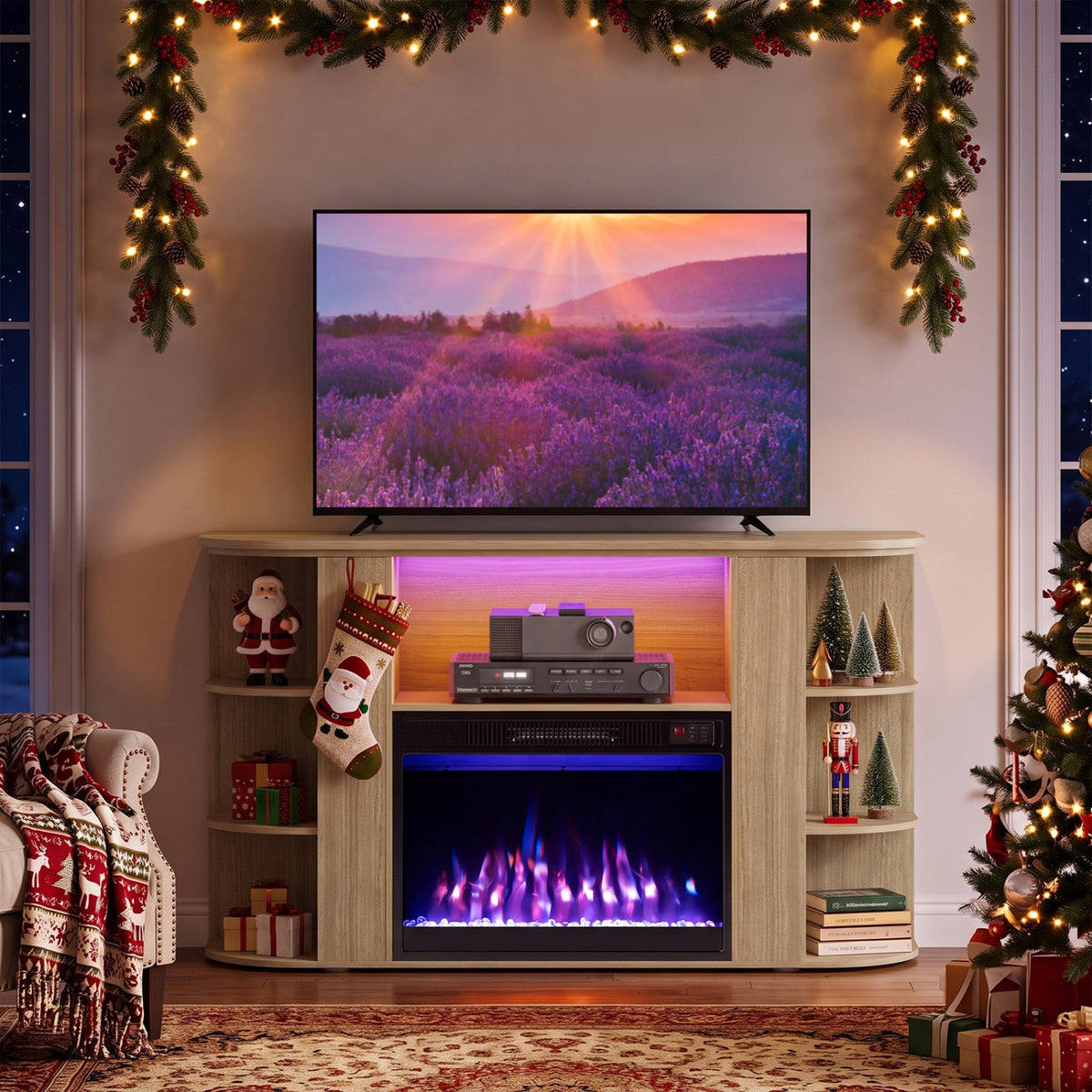 Light wood fireplace TV stand glowing purple and blue, styled with holiday decorations and a television above.