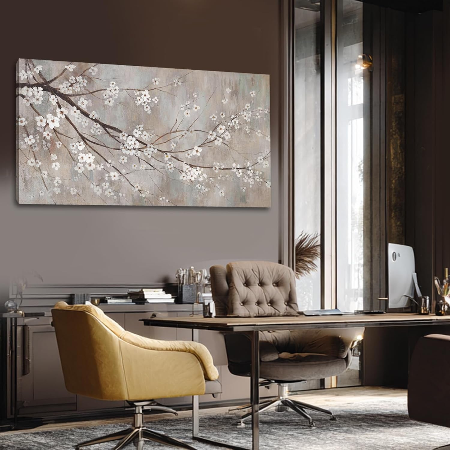 Plum blossom canvas panel on a dark office wall beside a leather swivel chair.