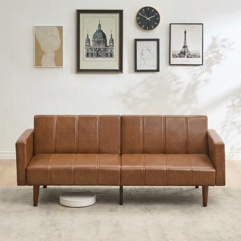 Brown PU leather futon sofa front view against a gallery wall showing full sofa length and tapered legs