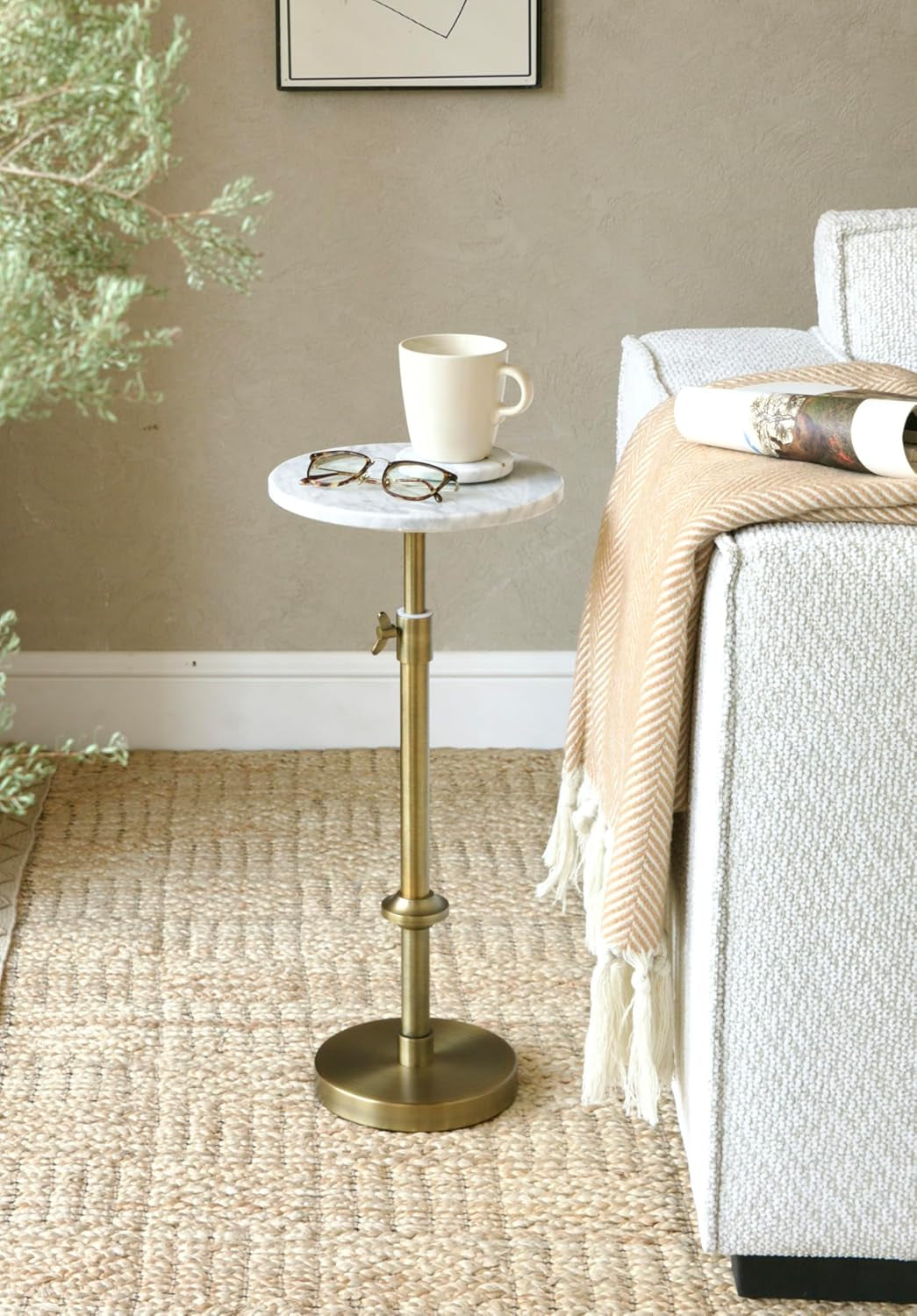 Marble drink table beside a sofa holding a cup and glasses in a living room setting
