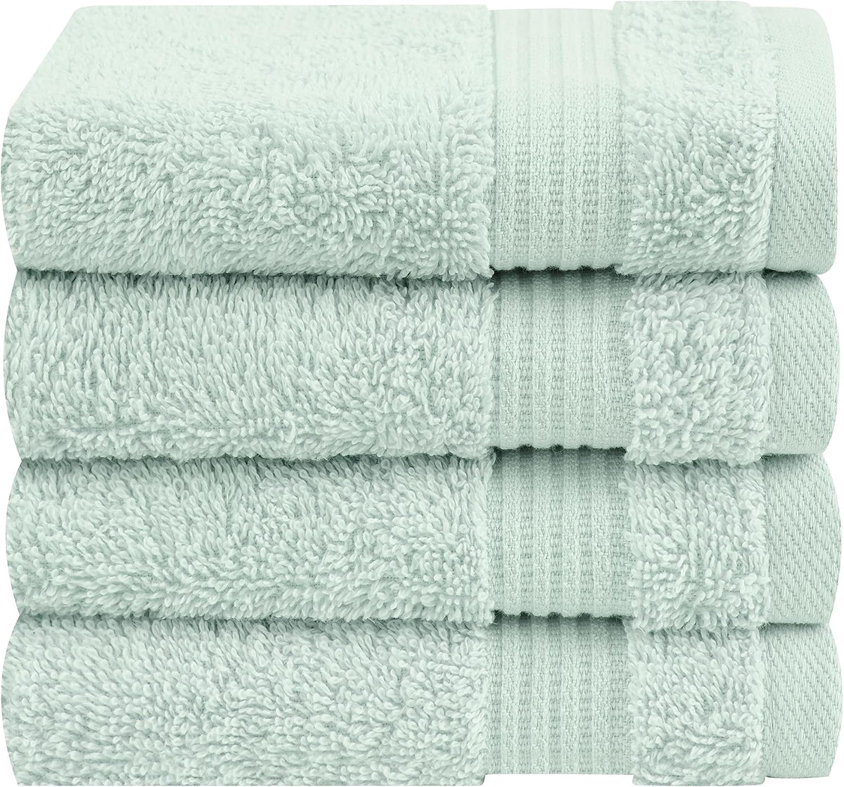Close-cropped stack of three pale mint green towels showing plush loops and a ribbed band at the edge.