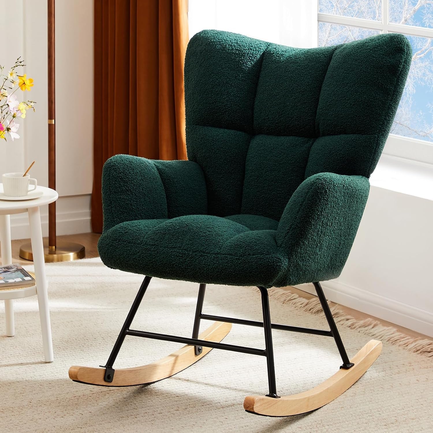 Dark green upholstered rocking chair with black metal frame and wooden rockers near a window.