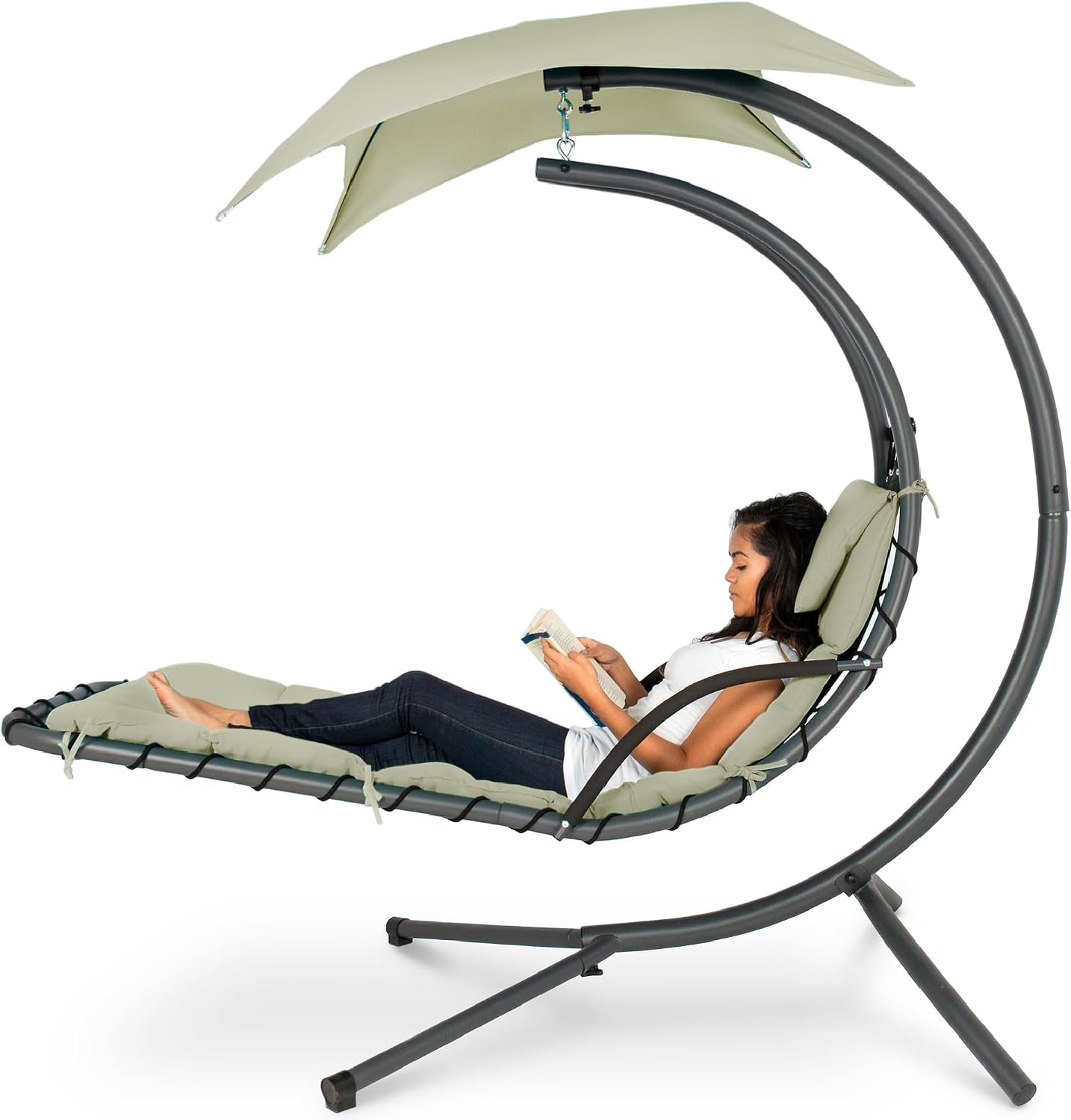 Curved hanging chaise with light beige cushion and canopy, woman reclined reading a book.
