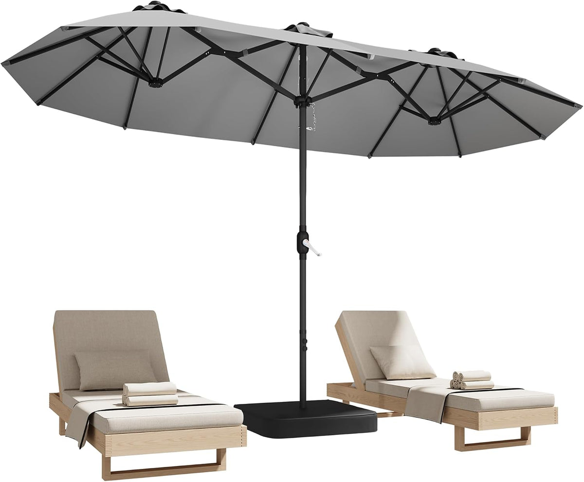 Studio view of a grey rectangular umbrella open over two lounge chairs and a square base.