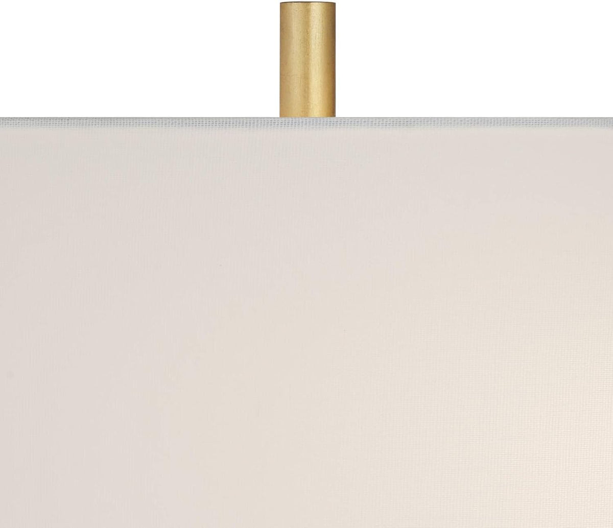 Close-up of the off-white fabric drum shade showing the top edge and finial