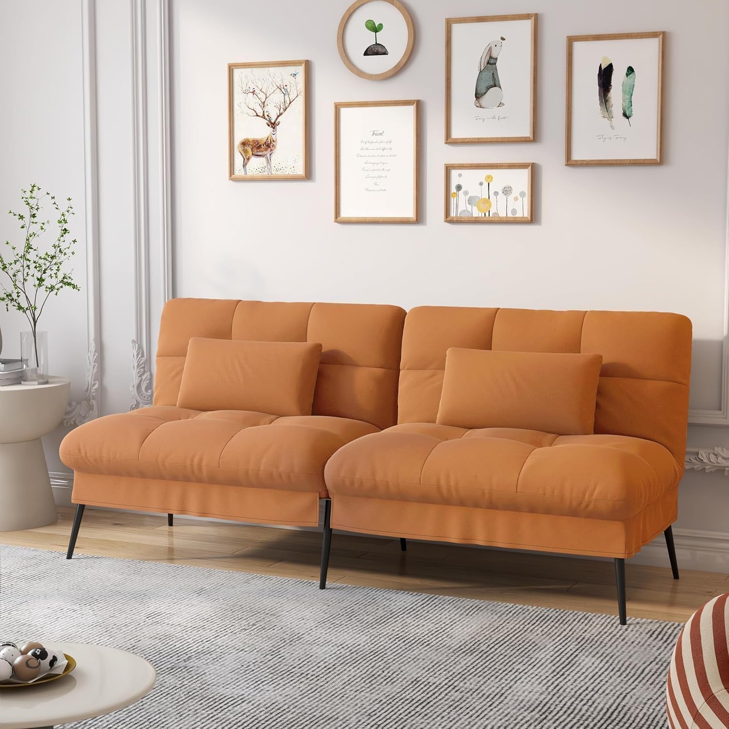 Warm orange futon sofa with tufted seats and two lumbar pillows in a bright living room.